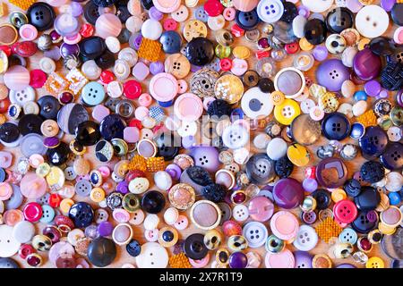 A vibrant collection of assorted buttons forms a textured mosaic, perfect for sewing and design projects Stock Photo