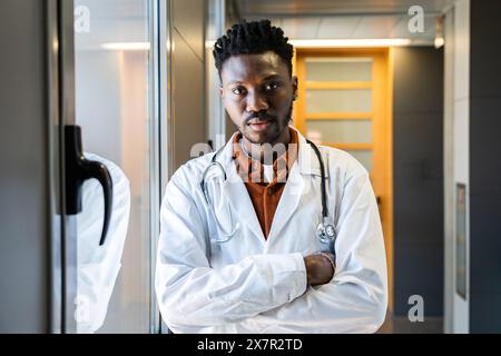 Confident male doctor stands ready in hospital corridor, prepared to discuss diabetes management and hypoglycemia prevention with patients Stock Photo