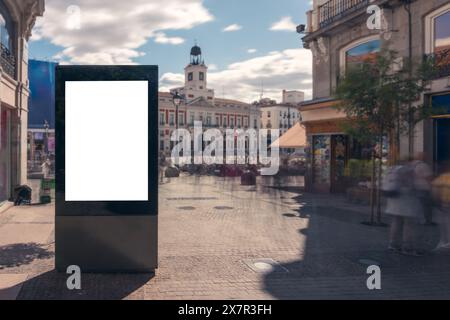 Blank advertising billboard mockup in a busy Madrid city square with blurred pedestrians and historical architecture Stock Photo