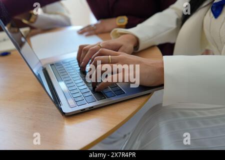 A close-up view showcasing two women working together on a laptop at a home setting, highlighting the concept of remote work Stock Photo
