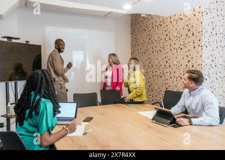 A team of professionals collaborates in a modern coworking office, reflecting diversity and teamwork in a business setting Stock Photo