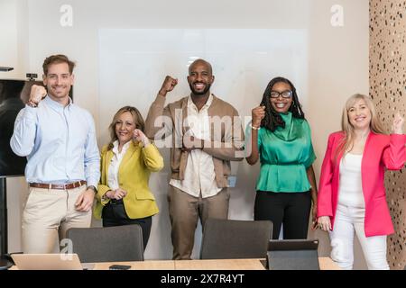 A multicultural team of professionals cheerfully celebrating a triumph in a modern coworking office environment Stock Photo