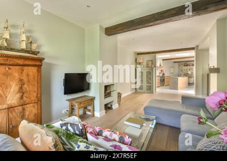Comfortable living room with a mix of rustic and modern elements, featuring a ship model, wood furniture, and a fireplace at Molenveenweg Stock Photo