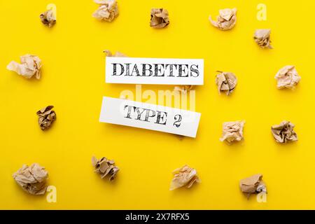 A yellow background with a pile of paper on it. The paper has the word diabetes written on it, and it is surrounded by other pieces of paper. Scene is Stock Photo