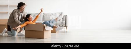 Playful young Asian couple having fun in their home Stock Photo