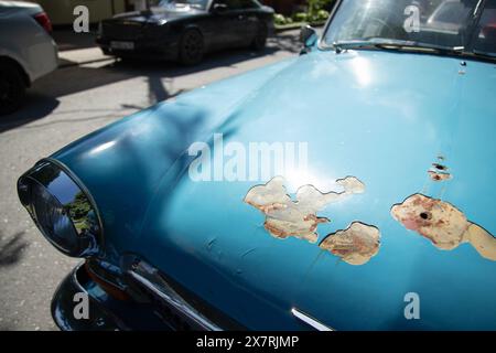Rusty cracked and peeling paint on an old blue  car. Stock Photo