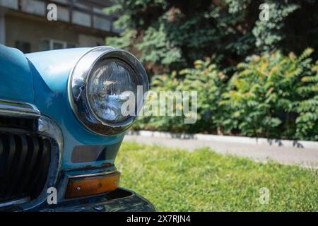 Old round headlight close up view . Copy space . front light details blue car Stock Photo