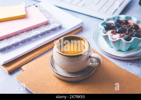 Coffee break in a office, cup of coffee with healthy yogurt in a office.  Workplace in a coffee shop or home office Stock Photo