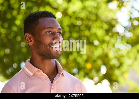 Head And Shoulders Portrait Of Smiling Man Outside Relaxing In Countryside Looking Off Camera Stock Photo