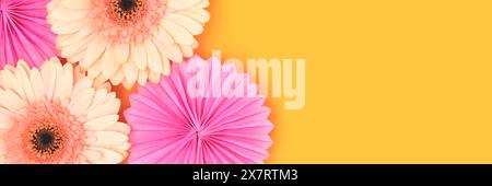 Banner with gerbera flowers and tissue paper fans on a yellow background. Stock Photo