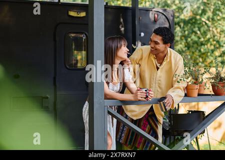 A man and a woman stand on a balcony, overlooking a scenic view, embracing each other in a serene moment of togetherness. Stock Photo