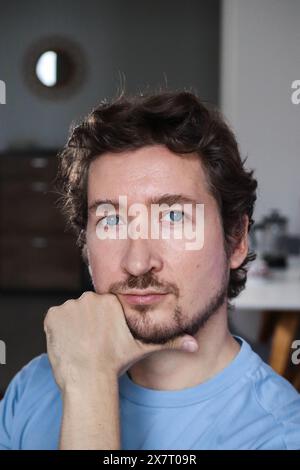 Handsome young man with blue eyes and curly wavy hair Stock Photo