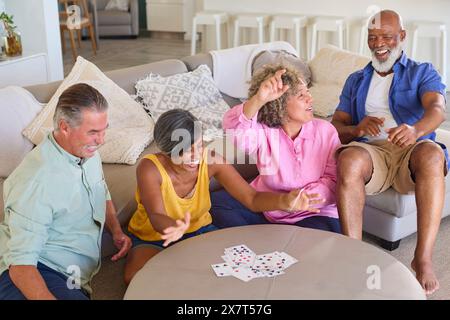 Group Of Mature Friends At Home Having Fun Playing Cards Together Stock Photo