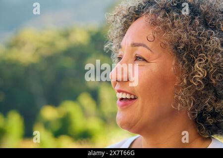 Close Up Portrait Of Laughing And Smiling Mature Woman Standing Outdoors In Countryside Stock Photo