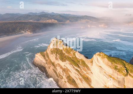 Aerial view of Picturesque sunrise shining over Wharariki beach and archway islands on Tasman sea at West of cape farewell, New Zealand Stock Photo