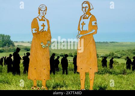 The British Normandy Memorial, France. Silhouettes of servicemen roaming through a field, donating the lost and fallen during the D-Day Landings, 1944 Stock Photo