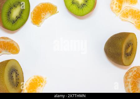 Flatlay from some peaces of yellow and green kiwi's and peaces of tangerine. On a white background. Stock Photo