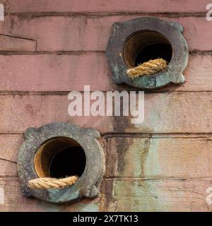 two boat anchor rope holes on an old wooden boat Stock Photo