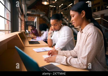 Male And Female Businesspeople Meeting In Office Discussing Documents With Colleagues In Background Stock Photo