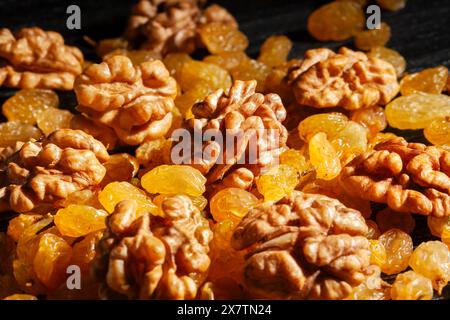 walnuts raisins on black wood background Stock Photo