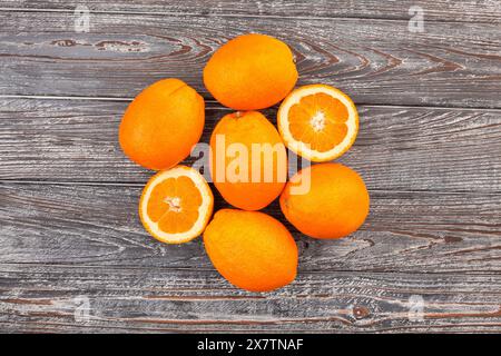 sliced calabrian oval blond oranges on wood background top view Stock Photo