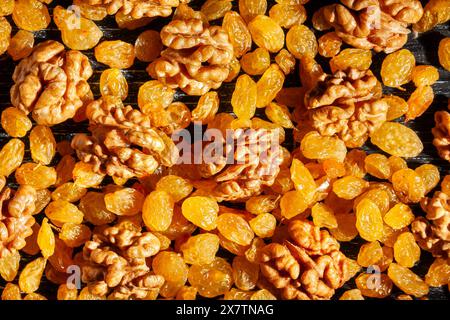 walnuts raisins on black wood background top view Stock Photo