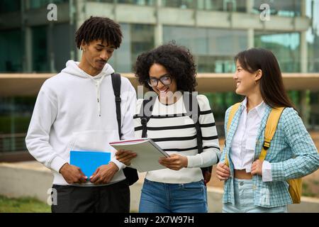 Multiethnic students are walking together, sharing notes from University Stock Photo