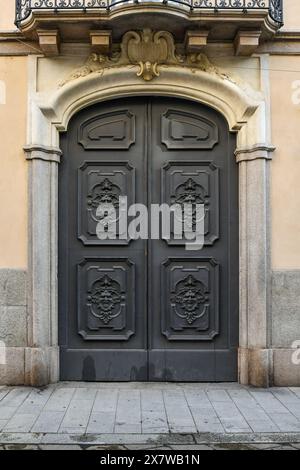 Entrance gate decorated with heads of satyrs or demons of Palazzo Citterio (18th century), Milan, Lombardy, Italy Stock Photo