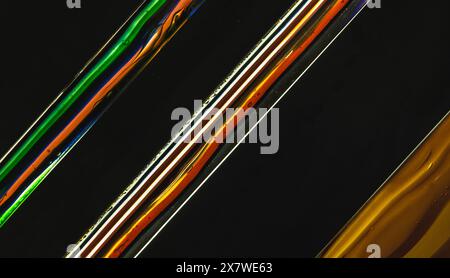 Abstract colorful glass fusing stripes pattern over black background, contemporary design elements, photo texture Stock Photo