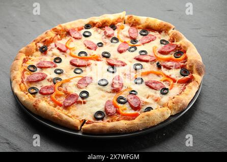 Tasty pizza with cheese, dry smoked sausages, olives, pepper and ...