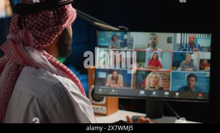 Arab man paying attention in elearning seminar teleconference. Middle Eastern student in online videocall with tutor and other colleagues, listening to lesson and participating Stock Photo