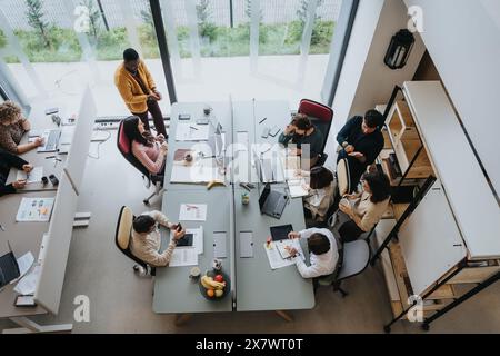 Top view photo of a successful team of diverse entrepreneurs collaborating indoors in an innovative office. Stock Photo