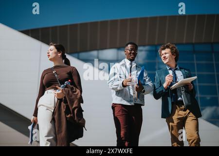 Mixed race business team discussing strategies outdoors with a modern building backdrop Stock Photo
