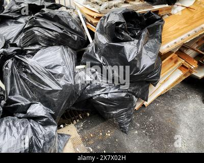 A pile of construction waste, trash bags full of garbage and broken pieces of wood at a construction site Stock Photo