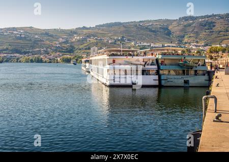 Peso da Régua, Portugal - October 05, 2023: Cruise boats on the Douro River moored at the Peso da Régua pier in Portugal. Stock Photo