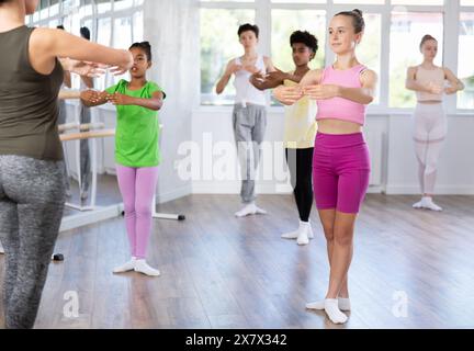 Teen girl practicing ballet movements at group class Stock Photo