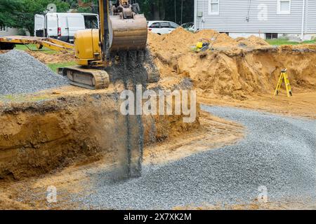 Excavators fill irregularities in excavations with granite rubble bases that will serve as foundations for concrete structures Stock Photo