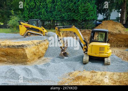 Construction site foundation is constructed by pouring concrete over rough edges in excavations made by an excavator Stock Photo