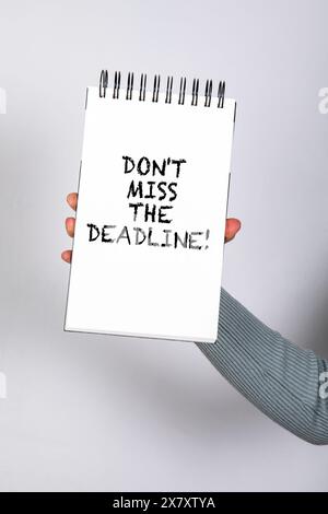 Don't miss the deadline. Notepad with text in woman's hand. Stock Photo