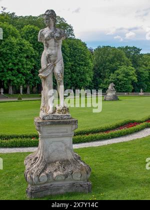 Weathered statue in a well-kept park with green lawns and surrounded by trees, park with green hedges, small paths and old statues, nordkirchen, germa Stock Photo
