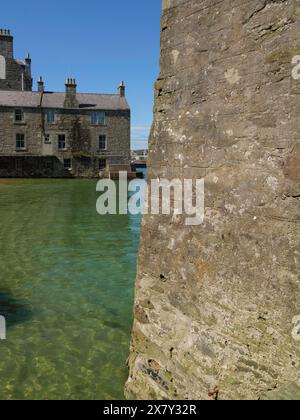 View of a massive stone wall and stone houses by the sea, old stone house by the blue sea against a blue sky, lerwick, Scotland, United Kingdom, Europ Stock Photo