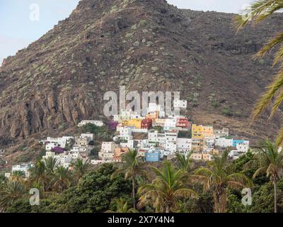 Small village with colourful houses on a rocky mountain, surrounded by palm trees and lush vegetation, mountains and valleys on an island in the Atlan Stock Photo