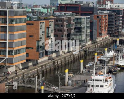 Modern residential buildings along a canal with moored ships, urban flair, many ships in a harbour with a beautiful promenade, HAmburg, Germany, Europ Stock Photo