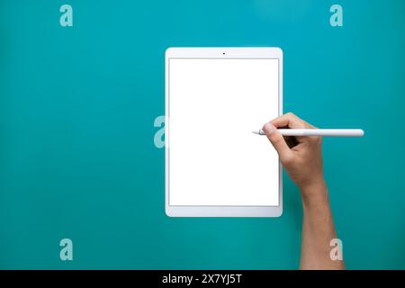 technology tablet, headphones, pencil on neutral green background with cardboard texture Stock Photo