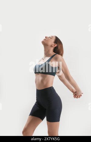 Young woman practicing stretching yoga positions, wellbeing and self care concept Stock Photo
