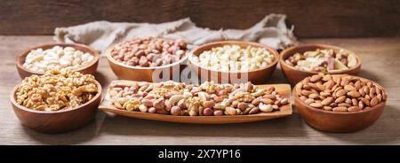 bowls of various mixed nuts on wooden table Stock Photo