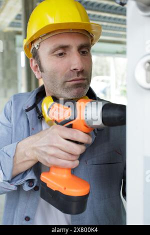 close-up of worker using power drill Stock Photo