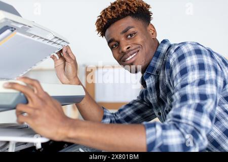 handsome young man using a copy machine Stock Photo
