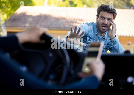 woman driving and using smartphone about to hit pedestrian Stock Photo