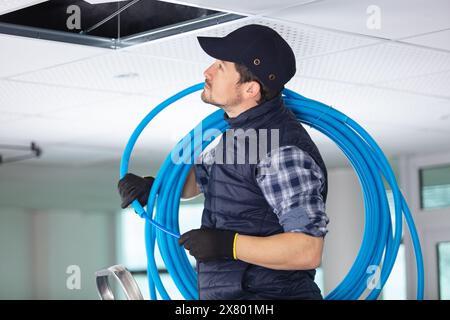 male construction worker installing cable ducting Stock Photo